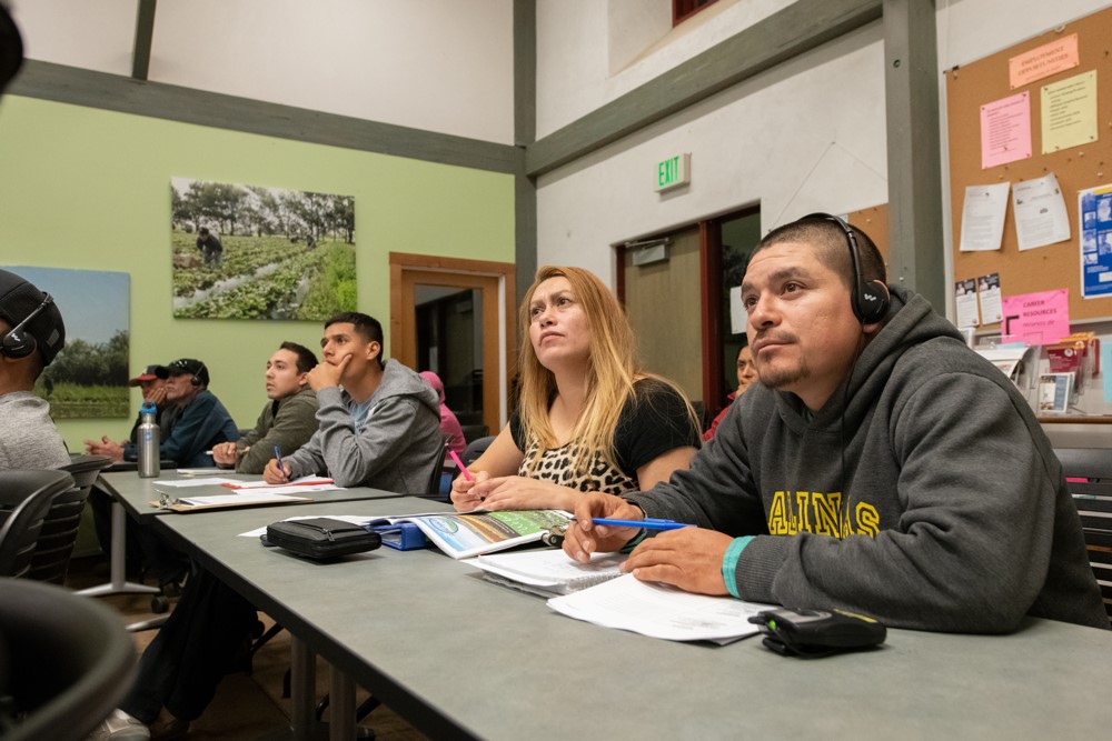 A group of students listen intently to a lecture on soil conservation. 