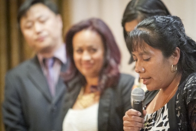 woman-speaking-into-microphone-with-people