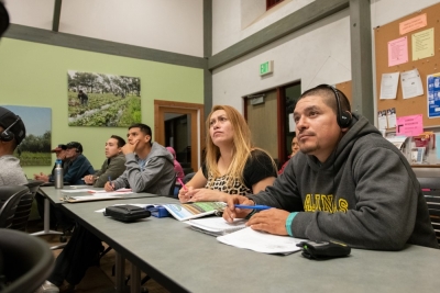 A group of students listen intently to a lecture on soil conservation. 