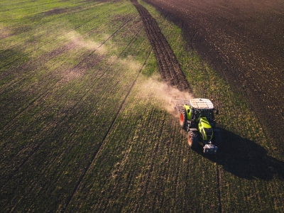 A tractor drives across a rural field.