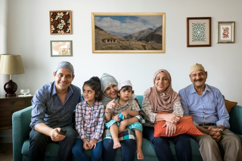 Multiple generations of a family sit on a couch together